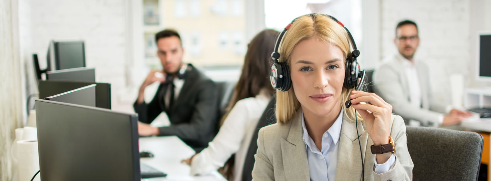 tech support call center focused on blonde woman wearing headeset