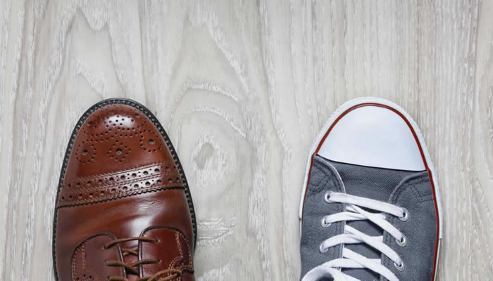 two shoes, dress shoe on the left, sneaker on the right viewed from the top.